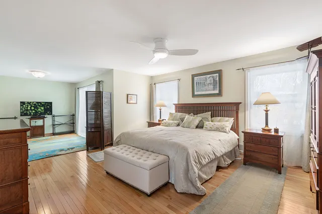 a spacious bedroom with a bed windows and a couch