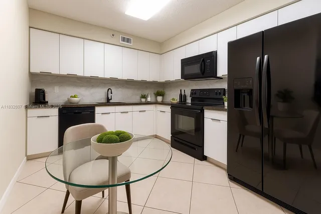 a kitchen with stainless steel appliances granite countertop a stove a refrigerator a sink a dining table and chairs