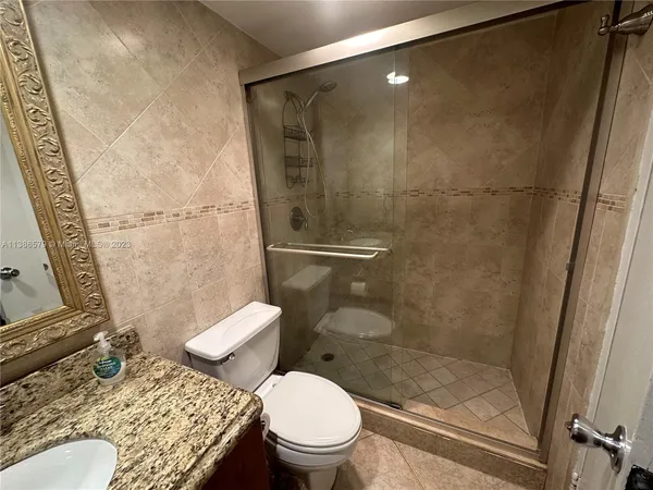 a white toilet sitting next to a bath tub and a shower