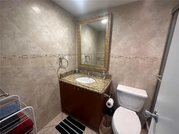 a bathroom with a granite countertop toilet sink and mirror