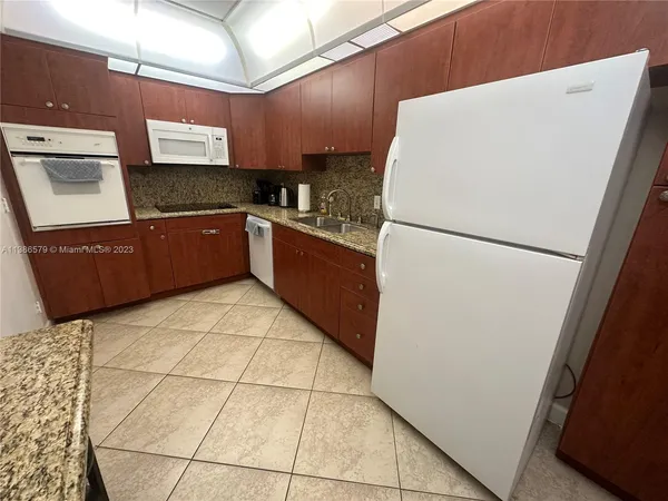 a kitchen with a refrigerator and a stove