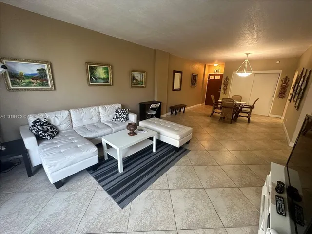 a living room with furniture and a dining table with wooden floor