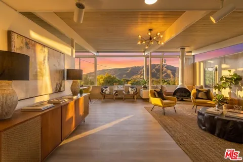 a very nice looking living room with furniture a flat screen tv and floor to ceiling window