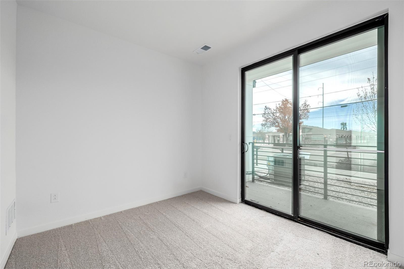 2076 South Holly Street, Unit 2 Denver, CO 80222 - Photo 14 of 24 a view of an empty room with sliding glass door