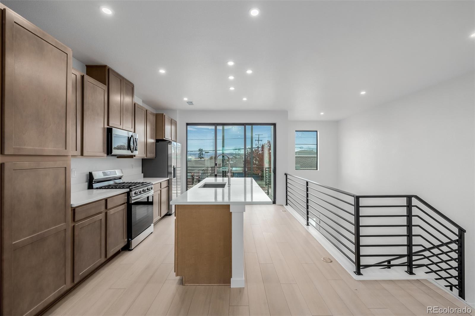 2076 South Holly Street, Unit 2 Denver, CO 80222 - Photo 4 of 22 a large kitchen with stainless steel appliances granite countertop a lot of counter space and wooden floor