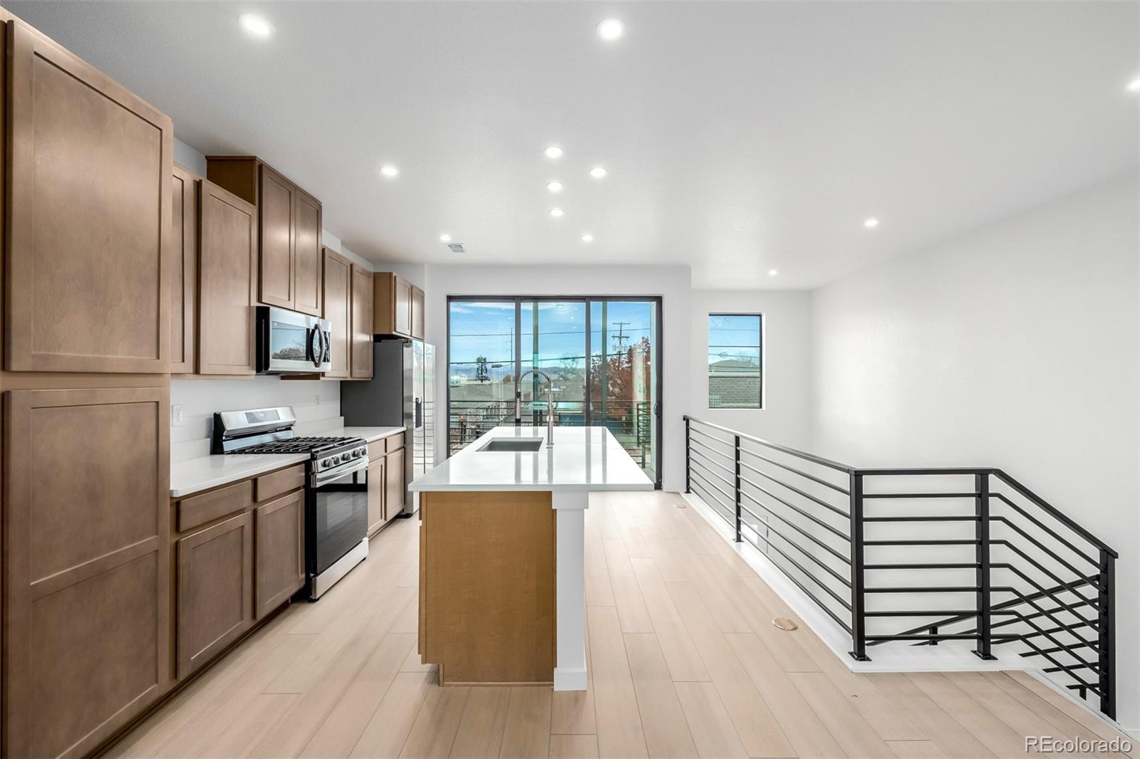 2076 South Holly Street, Unit 2 Denver, CO 80222 - Photo 5 of 24 a large kitchen with stainless steel appliances granite countertop a lot of counter space and wooden floor