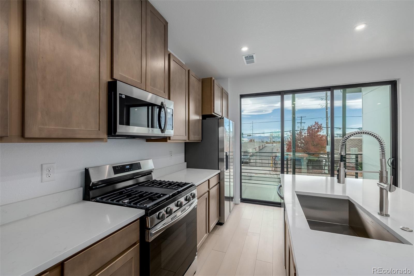2076 South Holly Street, Unit 2 Denver, CO 80222 - Photo 7 of 22 a kitchen with stainless steel appliances granite countertop a sink stove and refrigerator
