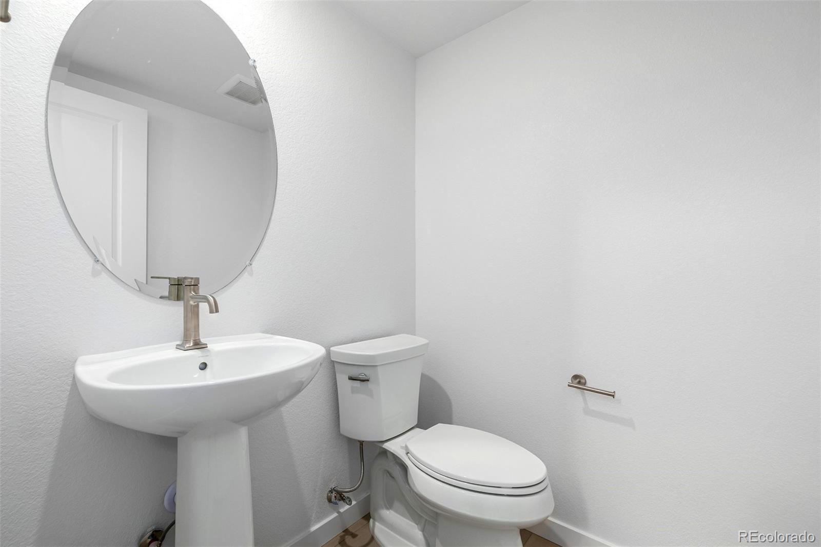 2076 South Holly Street, Unit 2 Denver, CO 80222 - Photo 7 of 24 a bathroom with a toilet sink and mirror