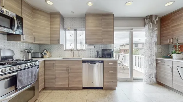 a kitchen with stainless steel appliances a stove sink and cabinets