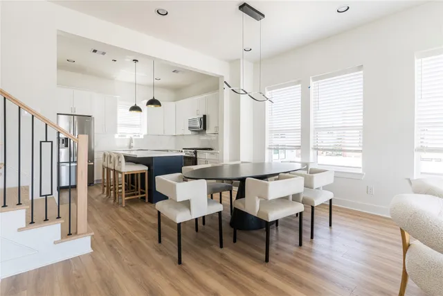 a kitchen with granite countertop a table chairs a sink dishwasher window and cabinets