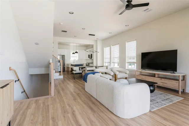 a living room with furniture a flat screen tv and a large window