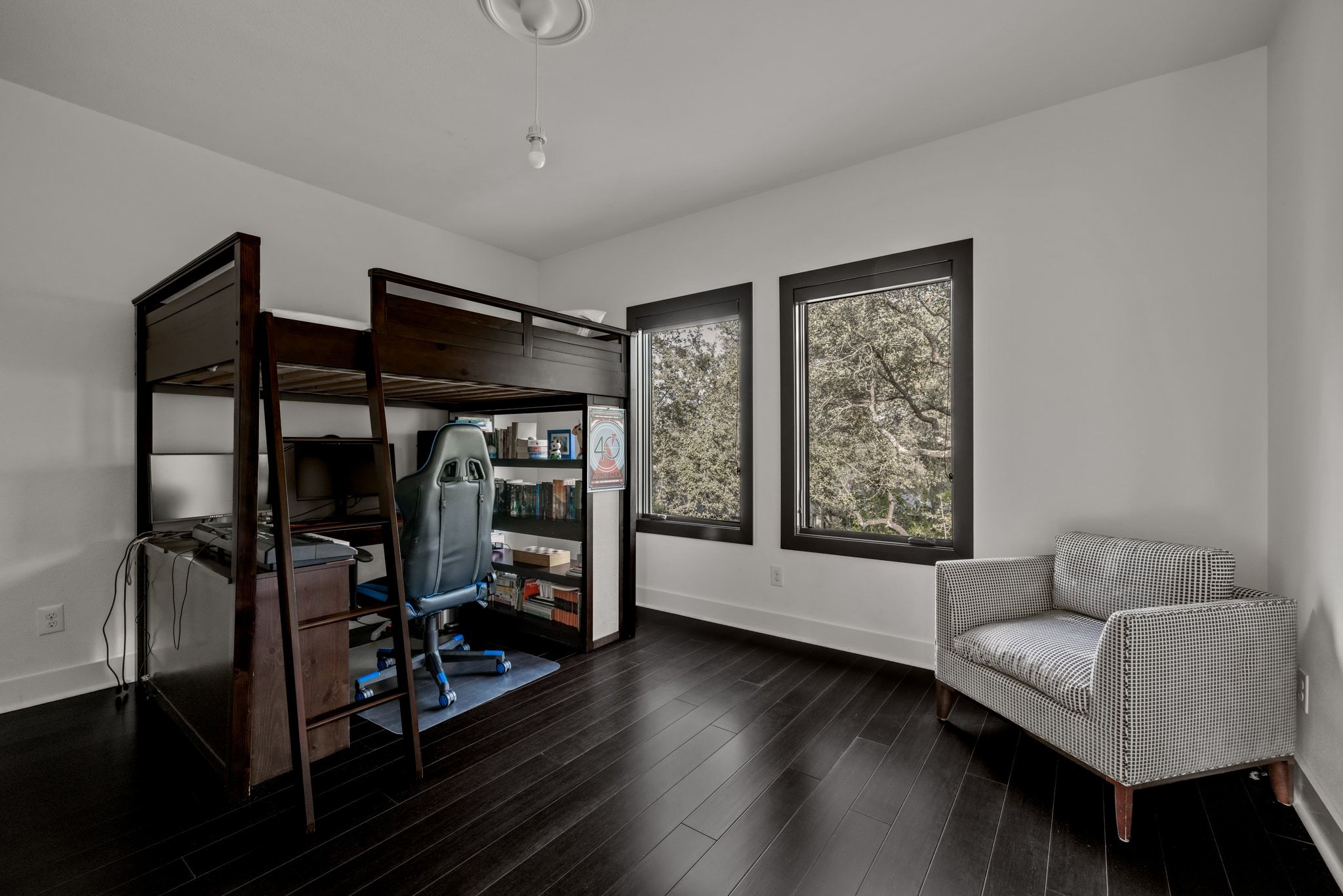 4720 Rockcliff Road, Unit 1 Austin, TX 78746 - Photo 33 of 39 Rich hardwood flooring grounds this inviting bedroom, featuring ample natural light through tall windows.