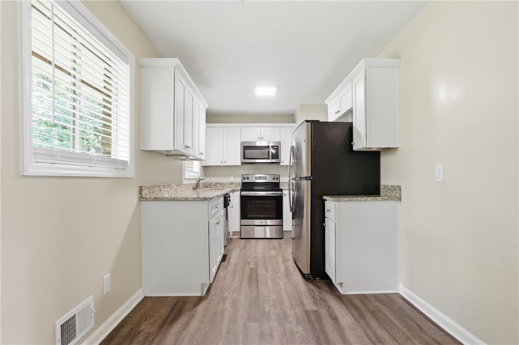 4505 Wonder Valley Trail Decatur, GA 30034 - Photo 7 of 34 a kitchen with wooden floors and refrigerator