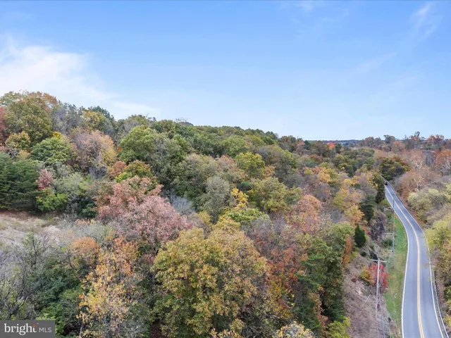 an aerial view of house with yard and mountain view in back