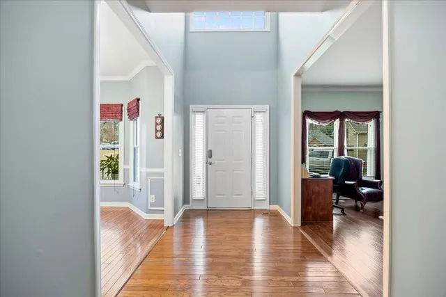 a view of a hallway with wooden floor and furniture