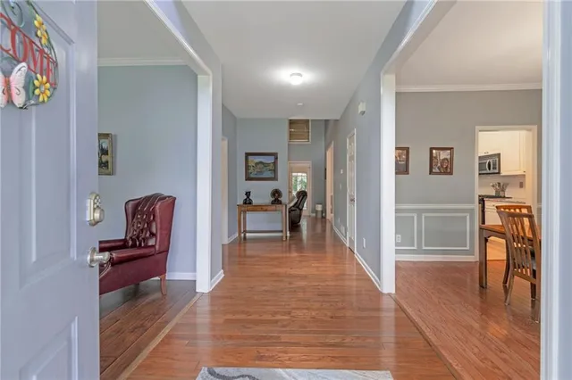 a view of a hallway with wooden floor and furniture
