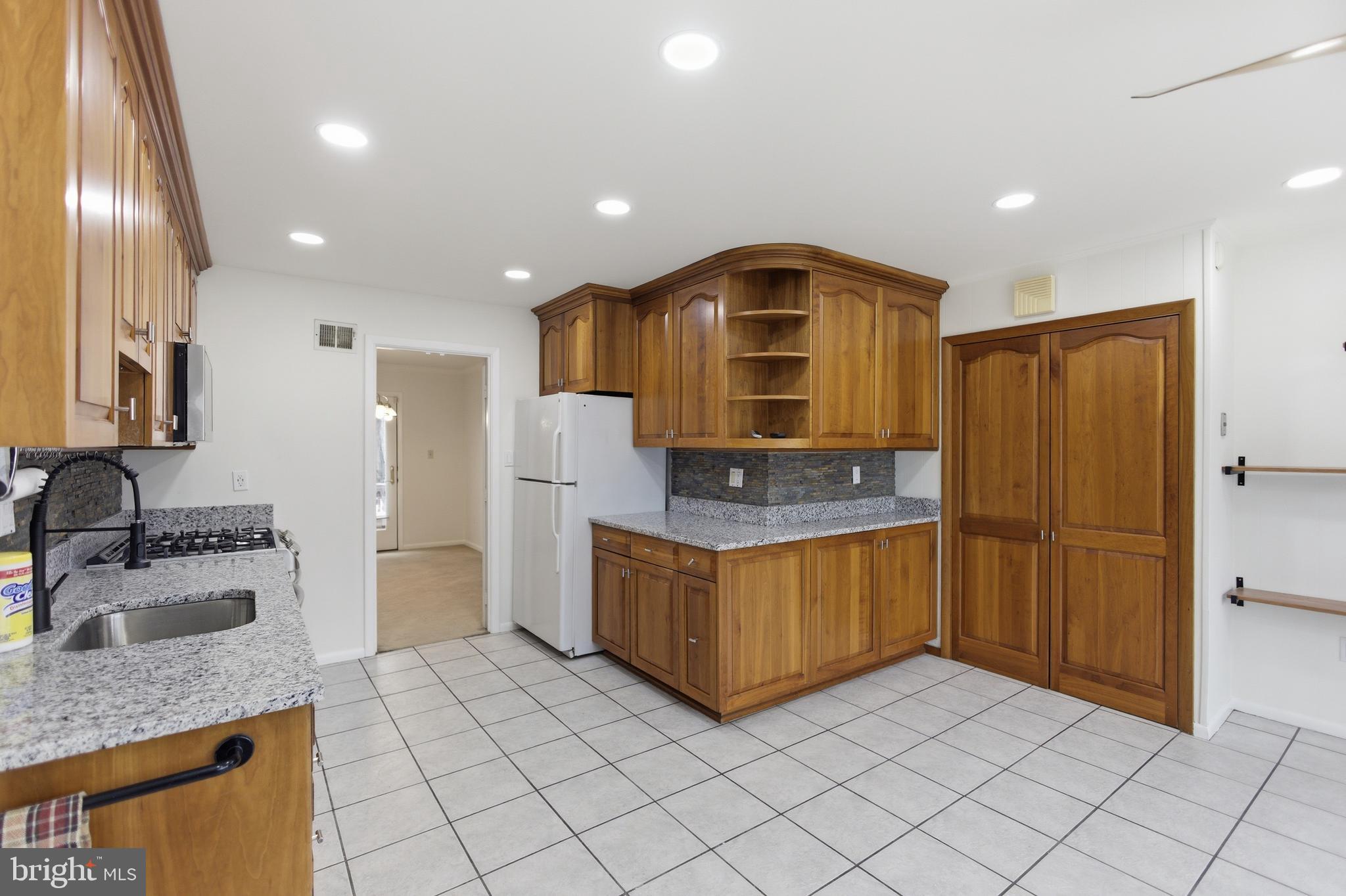 14717 Flintstone Lane Silver Spring, MD 20905 - Photo 11 of 32 a kitchen with sink refrigerator and microwave