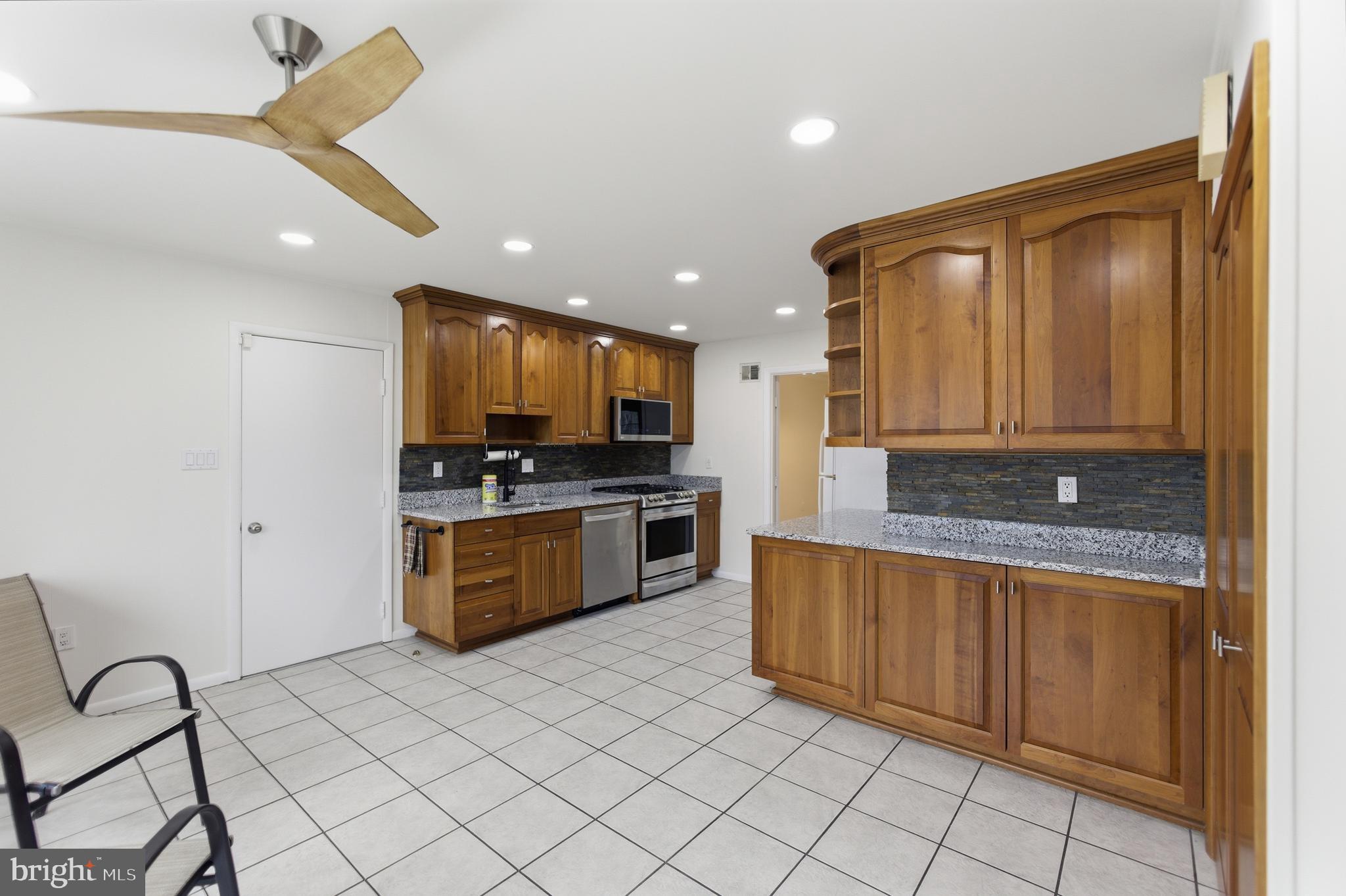 14717 Flintstone Lane Silver Spring, MD 20905 - Photo 13 of 32 a kitchen with stainless steel appliances granite countertop a stove a sink and a refrigerator