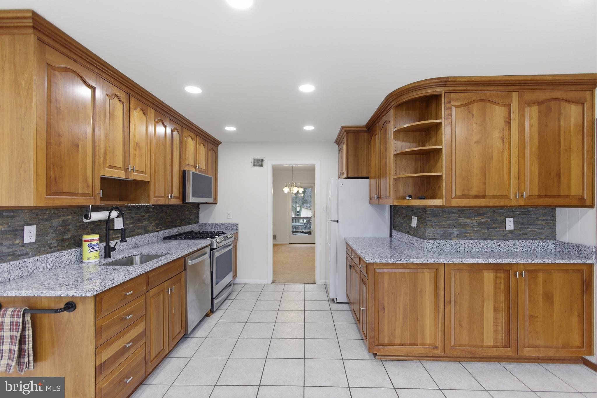 14717 Flintstone Lane Silver Spring, MD 20905 - Photo 7 of 32 a kitchen with a sink a counter top space cabinets and stainless steel appliances