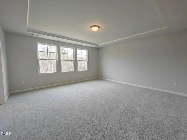 an empty room with a fireplace and windows