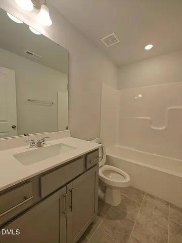 a bathroom with a sink a toilet and a large mirror