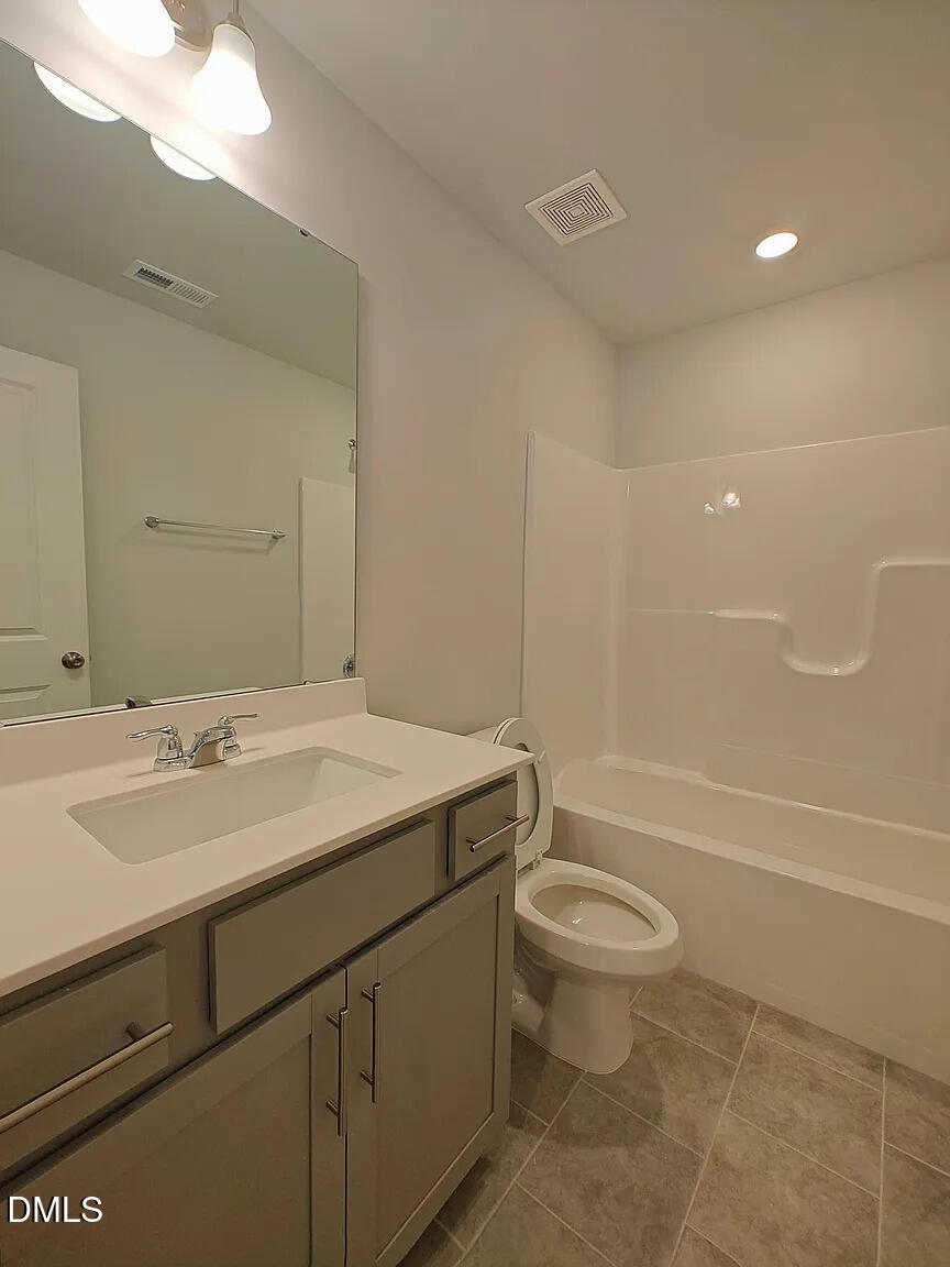1039 Red Wing Drive Durham, NC 27703 - Photo 2 of 40 a bathroom with a sink a toilet and a large mirror