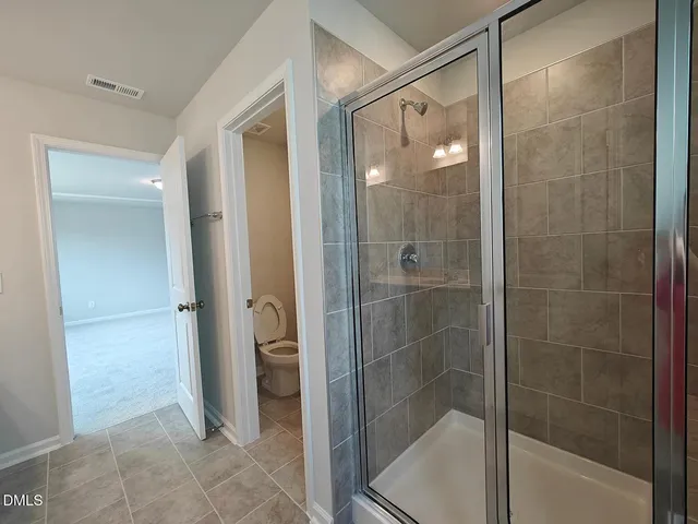 a bathroom with a glass shower door and a bathroom sink