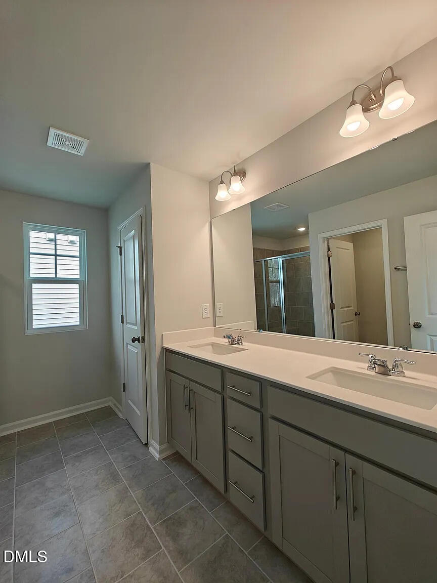 1039 Red Wing Drive Durham, NC 27703 - Photo 23 of 40 a spacious bathroom with a double vanity sink mirror and next to a window