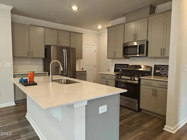 a kitchen with stainless steel appliances a microwave sink refrigerator and cabinets
