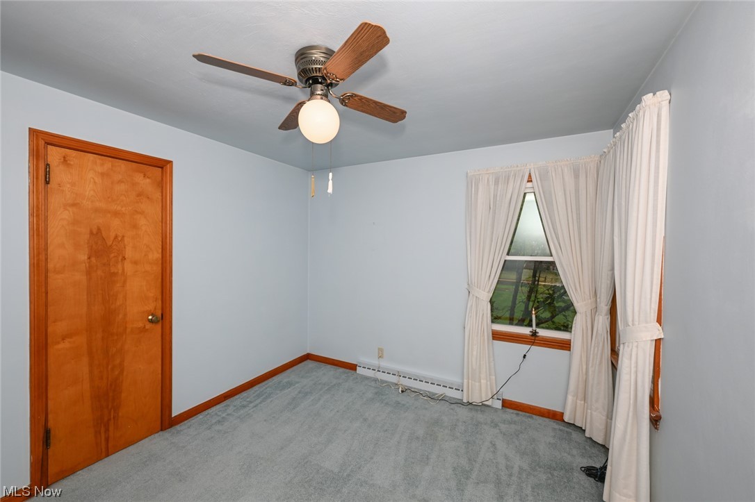 849 Bears Den Road Youngstown, OH 44511 - Photo 9 of 28 Carpeted empty room with baseboard heating and ceiling fan