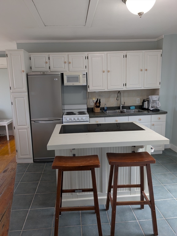 44 Old Point Road Newbury, MA 01951 - Photo 7 of 9 a kitchen with a table chairs and a stove