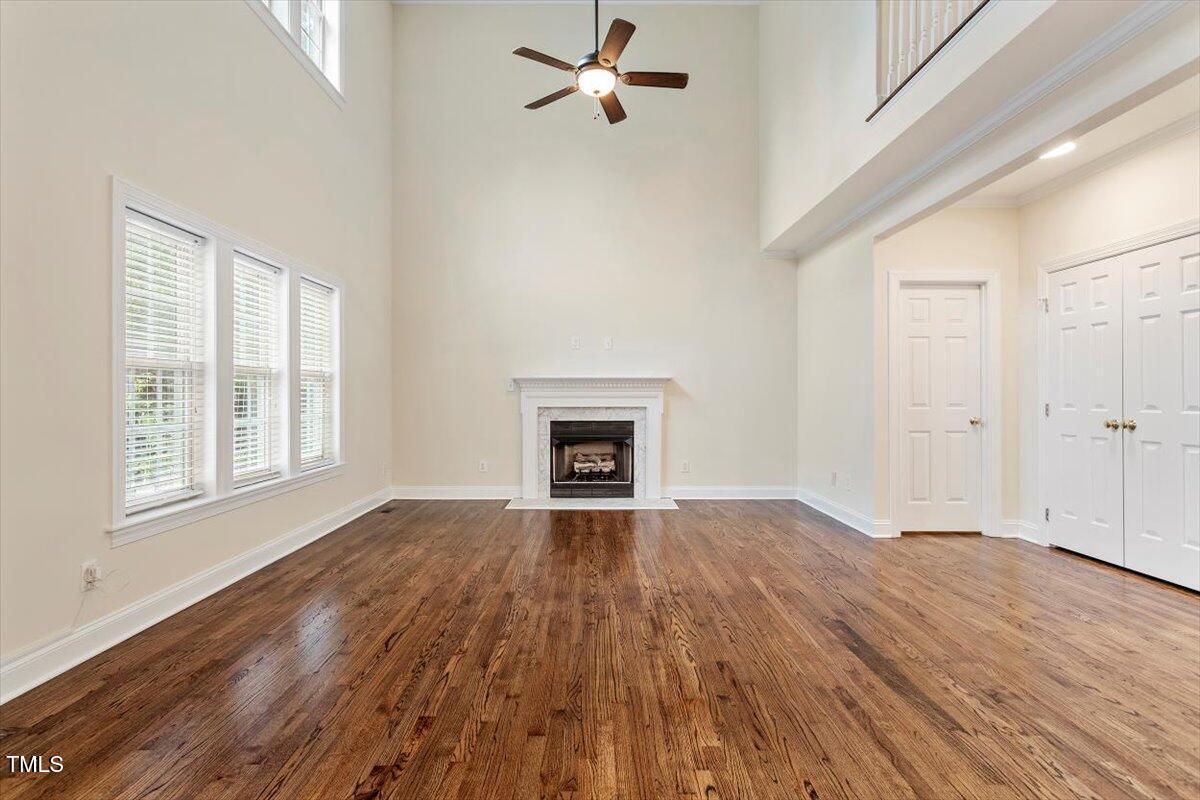 1817 Foxbrook Drive Raleigh, NC 27603 - Photo 22 of 61 an empty room with wooden floor fireplace and windows