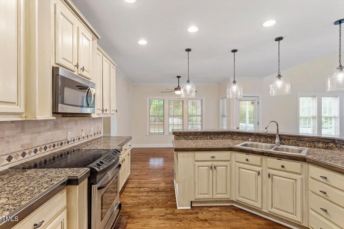 1817 Foxbrook Drive Raleigh, NC 27603 - Photo 30 of 61 a kitchen with stainless steel appliances granite countertop a sink a stove and a wooden cabinets