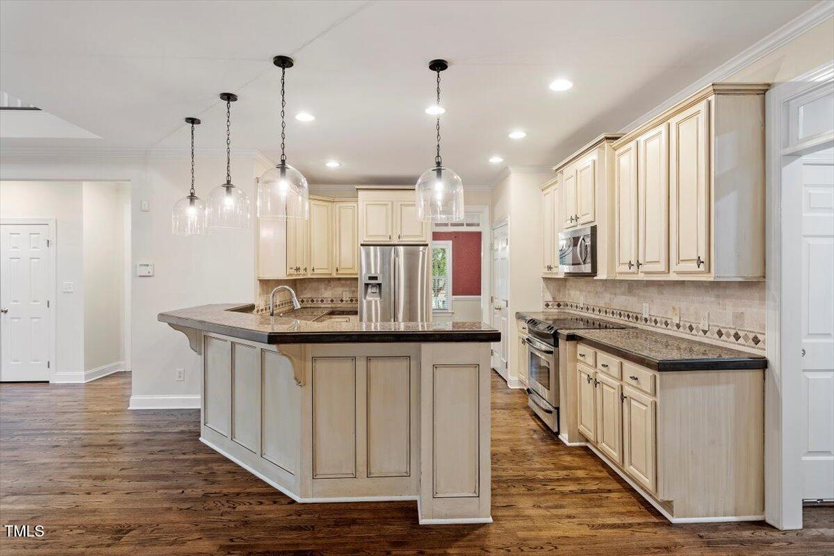 1817 Foxbrook Drive Raleigh, NC 27603 - Photo 32 of 61 a kitchen with stainless steel appliances granite countertop a sink a stove a refrigerator and a oven with wooden floor