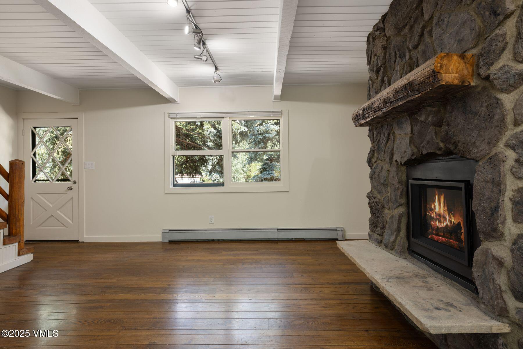 2456 Chamonix Lane, Unit B3 Vail, CO 81657 - Photo 2 of 29 a view of an empty room with wooden floor and a fireplace