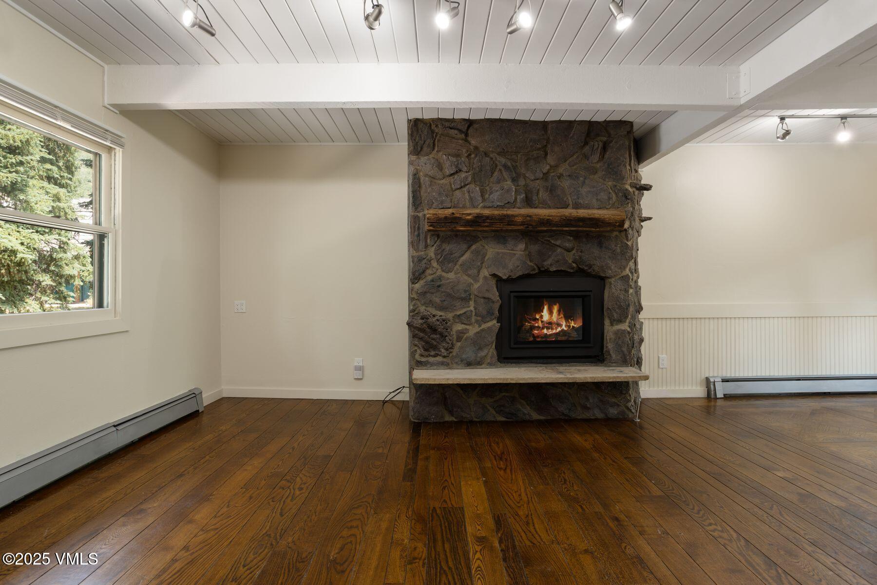 2456 Chamonix Lane, Unit B3 Vail, CO 81657 - Photo 5 of 29 an empty room with wooden floor fireplace and windows