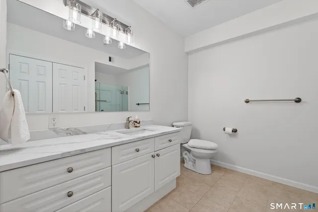 a bathroom with a toilet a sink and mirror