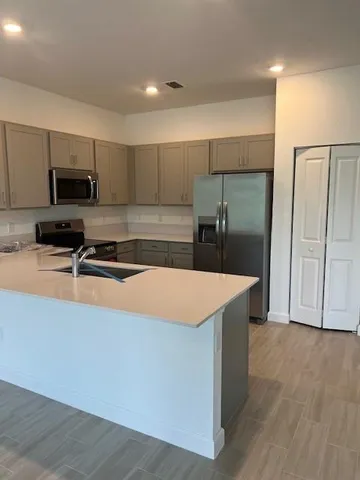 a kitchen with stainless steel appliances a refrigerator and a stove top oven