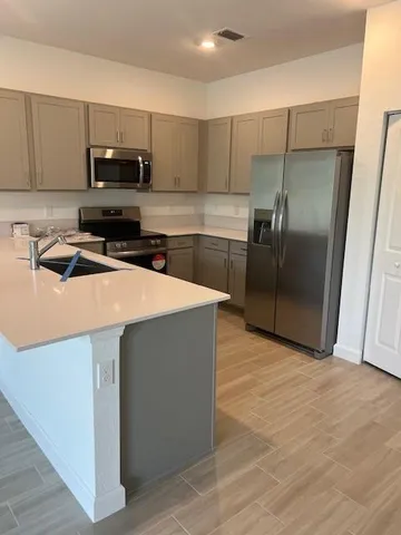 a kitchen with stainless steel appliances a refrigerator a stove a sink and a granite counter tops