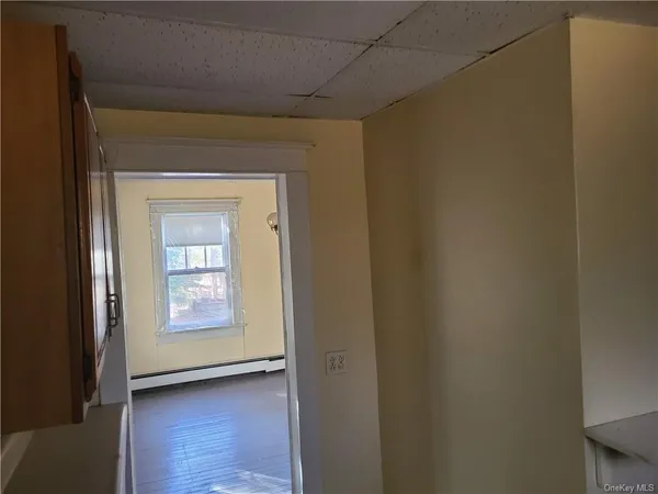 a view of a hallway with furniture and a window