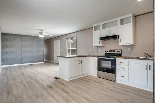a kitchen with granite countertop a stove and cabinets