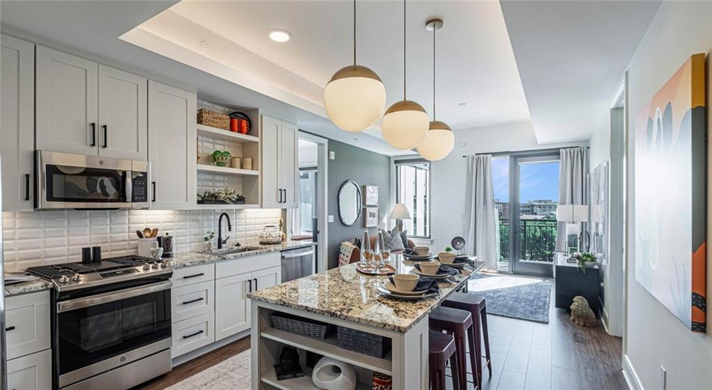 1301 Spring Street Northwest, Unit A3 Atlanta, GA 30309 - Photo 19 of 39 a kitchen with stainless steel appliances granite countertop a stove a sink dishwasher a refrigerator white cabinets and wooden floor