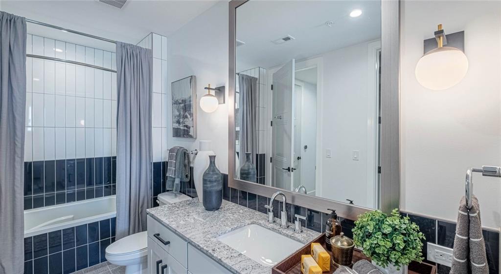 1301 Spring Street Northwest, Unit A3 Atlanta, GA 30309 - Photo 32 of 39 a bathroom with a granite countertop sink toilet a mirror and shower