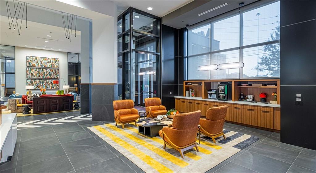 1301 Spring Street Northwest, Unit A3 Atlanta, GA 30309 - Photo 10 of 39 a living room with furniture a large window and kitchen view