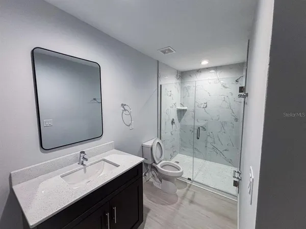 a bathroom with a sink a toilet and shower