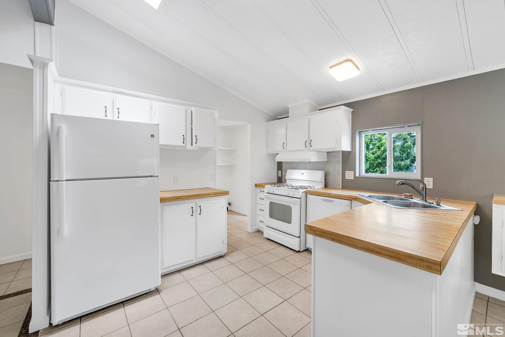 2177 Barberry Way Reno, NV 89512 - Photo 7 of 27 a kitchen with white cabinets and white appliances