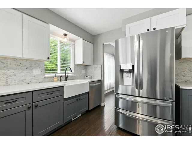 a kitchen with stainless steel appliances a stove and white cabinets