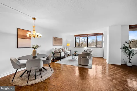 a living room with furniture a chandelier and a window