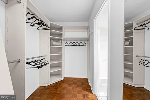 a view of walk in closet with empty racks