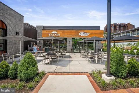 a view of a patio with couches and table and chairs under an umbrella